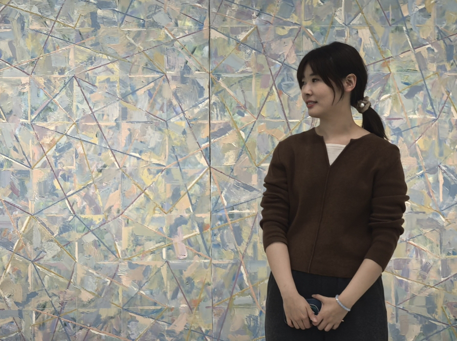 女人站在墙边AI 生成的内容可能不正确。